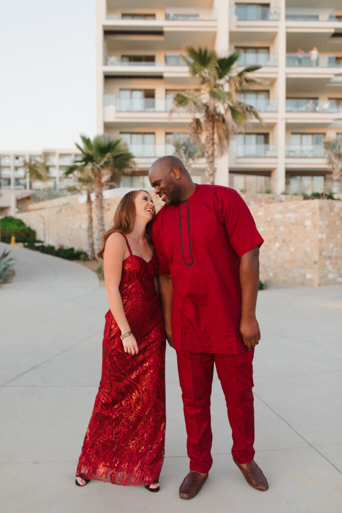 Bride and groom at their welcome party for their destination wedding weekend, where they played into the groom's family customs wearing red.