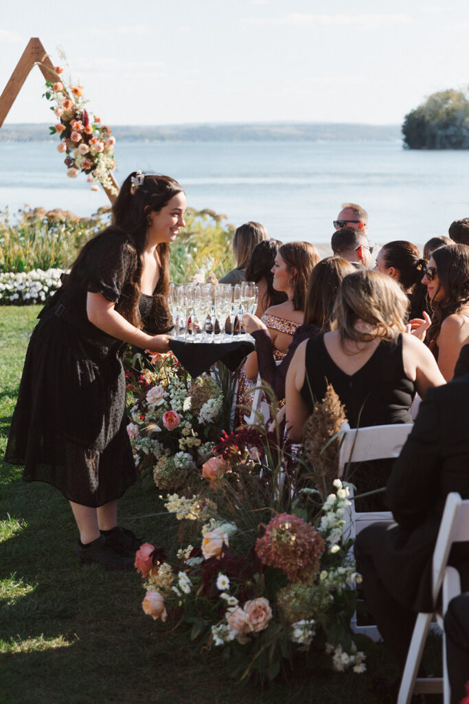 Guests are served glasses of champagne to enjoy the lakeside views before the wedding ceremony at The Lake House on Canandaigua.