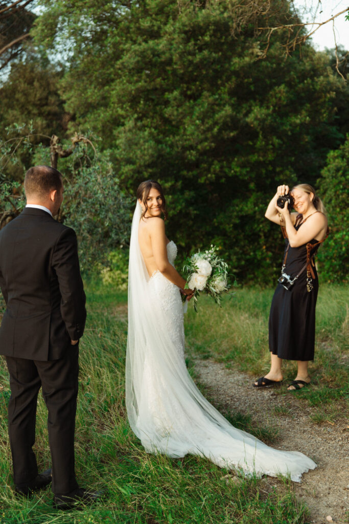 A wedding photographer photographing a husband and wife at their Tuscany, Italy wedding.